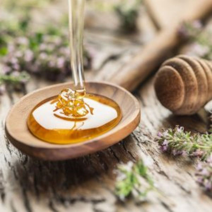 Honey Getting Poured Into A Wooden Spoon