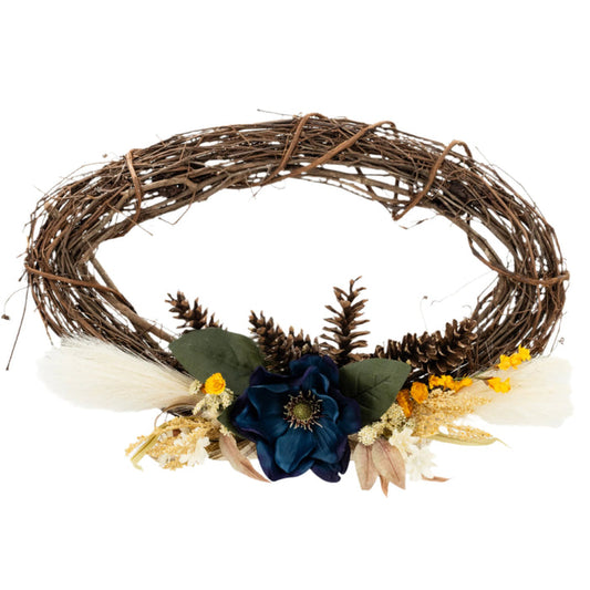 A decorative wreath made of twigs and adorned with artificial blue and yellow flowers and beige accents.