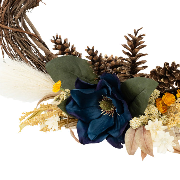 Details of a decorative wreath made of twigs and adorned with artificial blue and yellow flowers and beige accents.