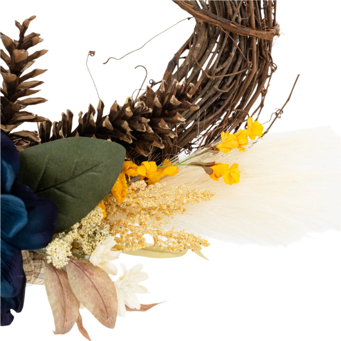 Details of a decorative wreath made of twigs and adorned with artificial blue and yellow flowers and beige accents.