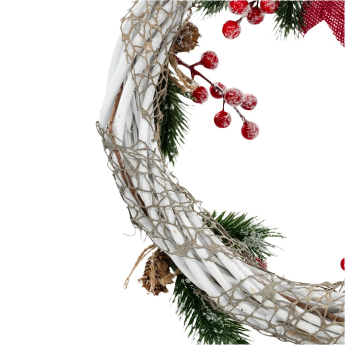 Closeup of a decorative Christmas wreath made with white wires, green pine needles, red berries, and a red bow, crafted by KJ Made.