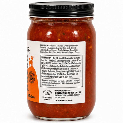 A jar of Childawg's Fine Foods Medium Heat chili oil with visible red-orange peppers and onions inside, featuring a black lid and a white label with text and a deer logo.
